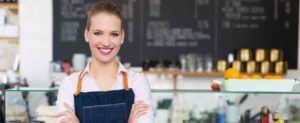 Frau steht in einem Restaurant und verschrenkt die Arme