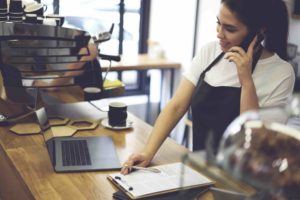 Frau telefoniert im Cafe mit Anwalt